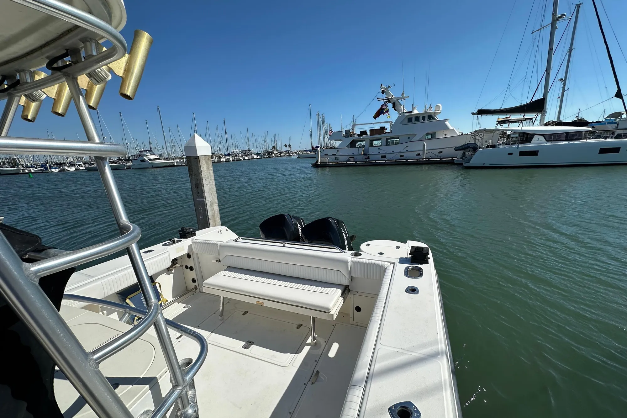 2001 Boston Whaler 28 Outrage boat docked in a marina with yachts in the background.