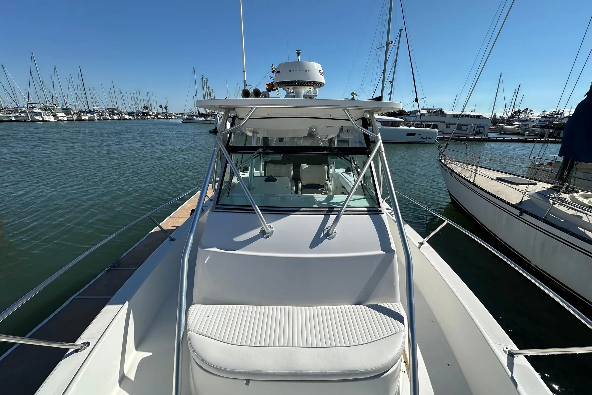 2001 Boston Whaler 28 Outrage boat docked in a marina, surrounded by sailboats.