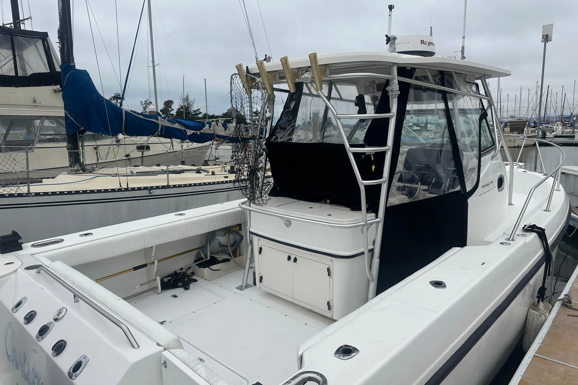 2001 Boston Whaler 28 Outrage boat docked at marina, featuring spacious deck and cabin.