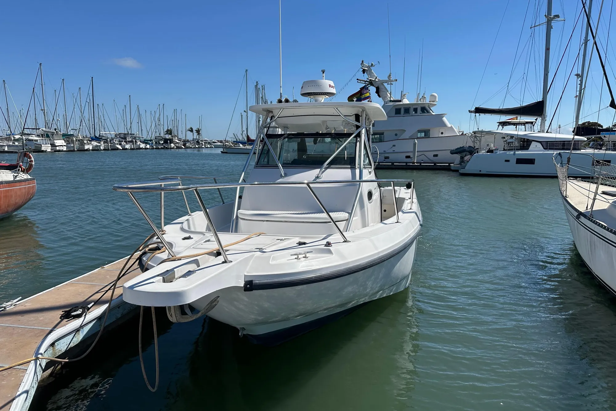 2001 Boston Whaler 28 Outrage boat docked in a marina under clear blue skies.