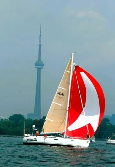  Yacht Photos Pics 2008 Beneteau 49 Oceanis Tall Rig sailing near iconic tower, vibrant red sail.