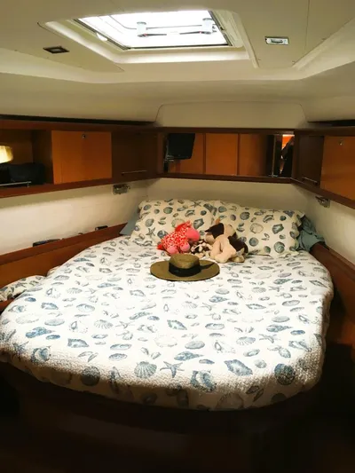  Yacht Photos Pics Cozy cabin interior of 2008 Beneteau 49 Oceanis Tall Rig with plush bedding and soft toys.
