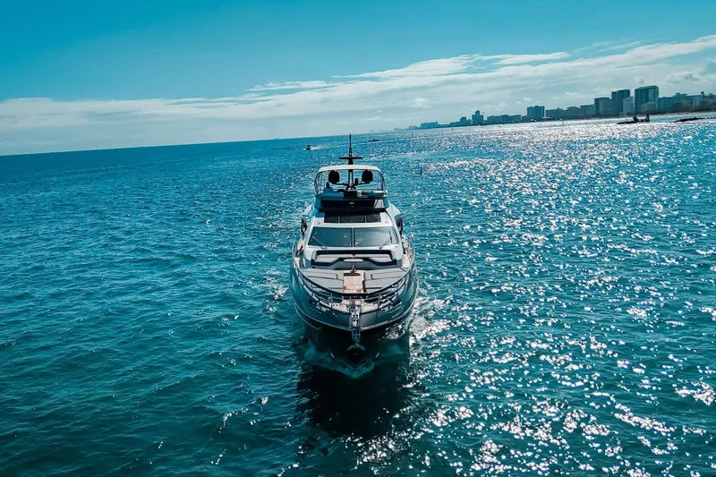  Yacht Photos Pics 2023 Azimut S8 yacht cruising on sparkling blue ocean near city skyline.