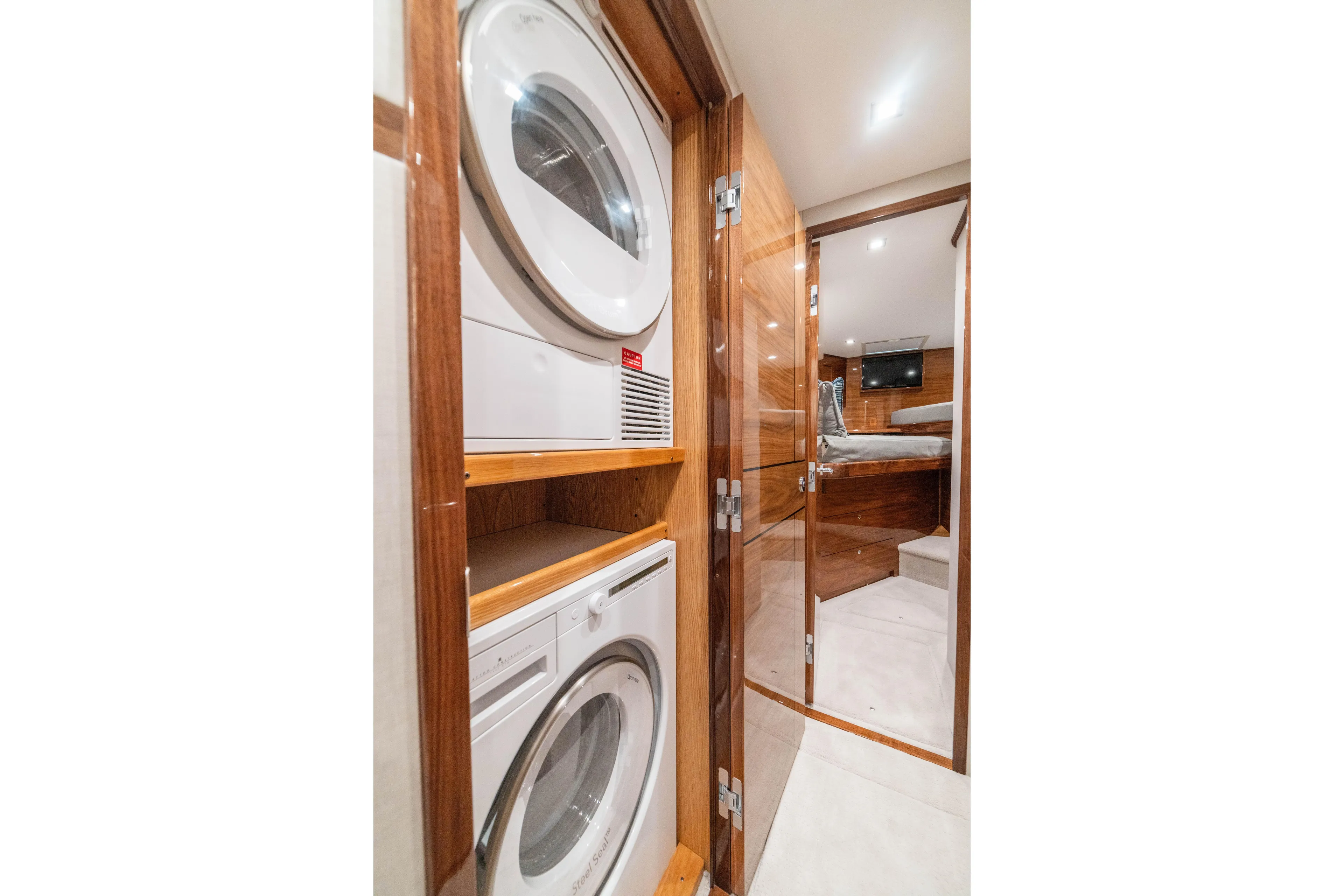 New Viking 64 Convertible Yacht Photos Pics Laundry area inside 2026 Viking 64 Convertible yacht, featuring stacked washer and dryer.