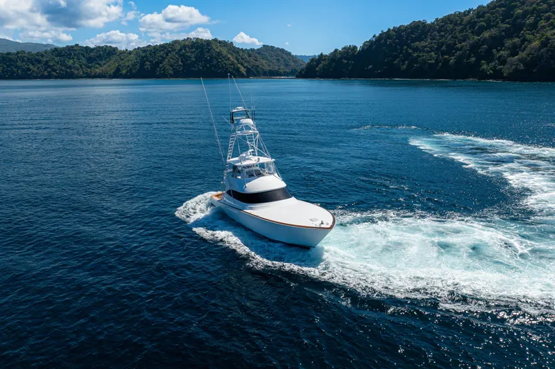 New Viking 64 Convertible Yacht Photos Pics 2026 Viking 64 Convertible yacht cruising on blue ocean near lush green islands.