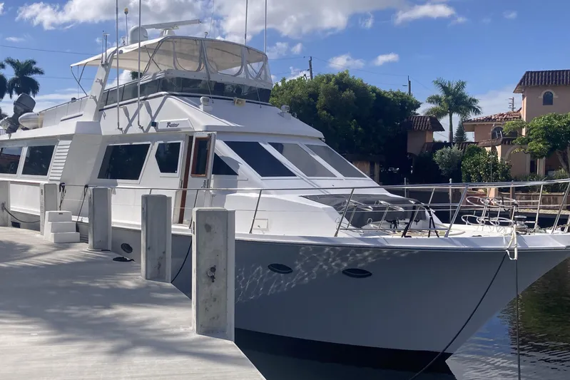 Raiders Yacht Photos Pics 1988 Viking 70 Cockpit Motor Yacht docked, surrounded by palm trees and clear skies.