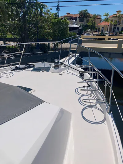 Raiders Yacht Photos Pics 1988 Viking 70 Cockpit Motor Yacht bow view, docked near waterfront homes.