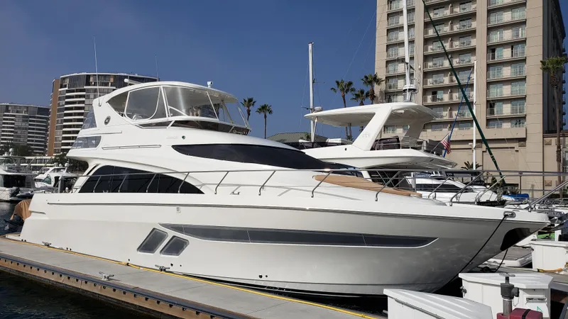 Happy Ours Yacht Photos Pics Luxury 2007 Marquis 55 LS yacht docked at marina with modern buildings in background.