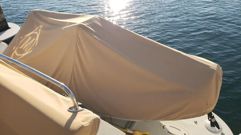 Happy Ours Yacht Photos Pics Covered 2007 Marquis 55 LS yacht on water, sun reflecting on surface.