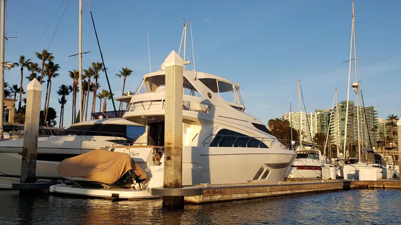 Happy Ours Yacht Photos Pics Luxury 2007 Marquis 55 LS yacht docked at marina, surrounded by sailboats and palm trees.