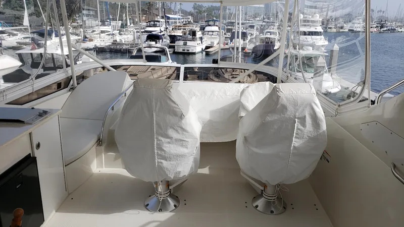 Happy Ours Yacht Photos Pics 2007 Marquis 55 LS yacht interior with covered seats, docked at a marina.