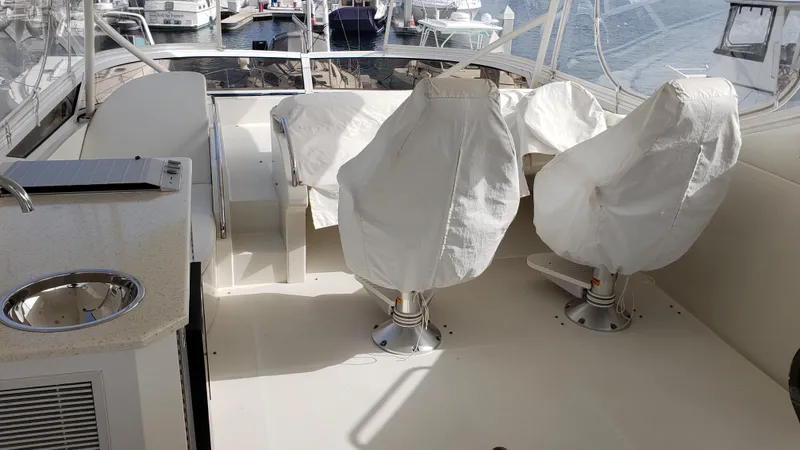 Happy Ours Yacht Photos Pics 2007 Marquis 55 LS yacht interior with covered seats and marina view.