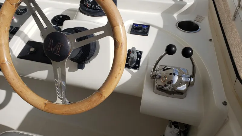 Happy Ours Yacht Photos Pics Steering wheel and controls of a 2007 Marquis 55 LS yacht cockpit.