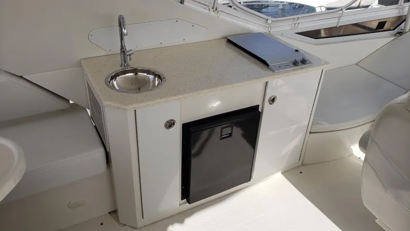 Happy Ours Yacht Photos Pics 2007 Marquis 55 LS yacht kitchenette with sink, mini fridge, and countertop.