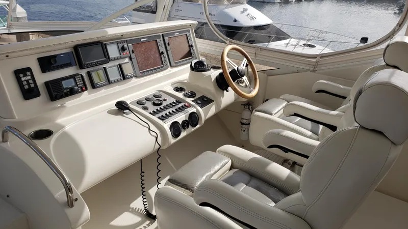 Happy Ours Yacht Photos Pics Luxurious 2007 Marquis 55 LS yacht cockpit with advanced navigation controls and plush seating.