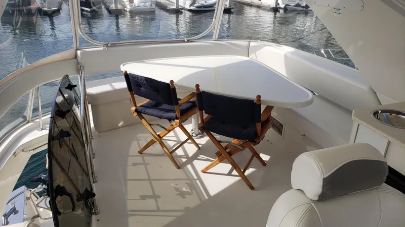 Happy Ours Yacht Photos Pics 2007 Marquis 55 LS yacht interior with table, chairs, and marina view.