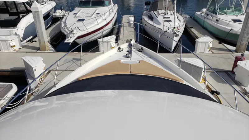 Happy Ours Yacht Photos Pics Bow view of a 2007 Marquis 55 LS yacht docked among other boats.