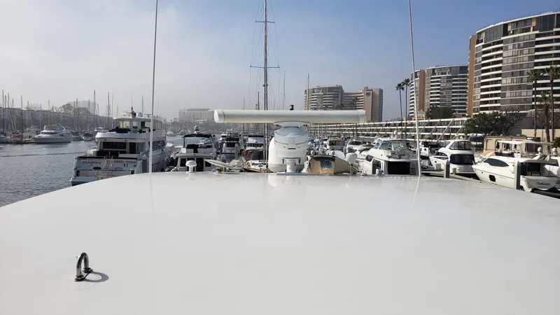 Happy Ours Yacht Photos Pics 2007 Marquis 55 LS yacht docked in a marina with surrounding boats and buildings.