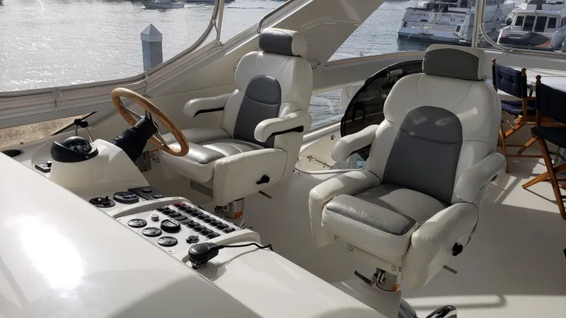 Happy Ours Yacht Photos Pics Luxury interior of 2007 Marquis 55 LS yacht with plush captain chairs and control panel.
