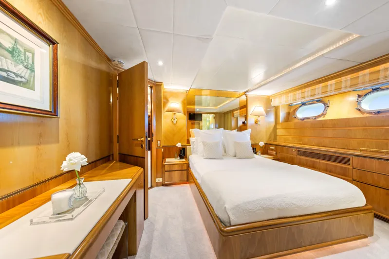 Mistress Yacht Photos Pics Luxurious bedroom interior on a 1991 Benetti 46m yacht, featuring elegant wood paneling.
