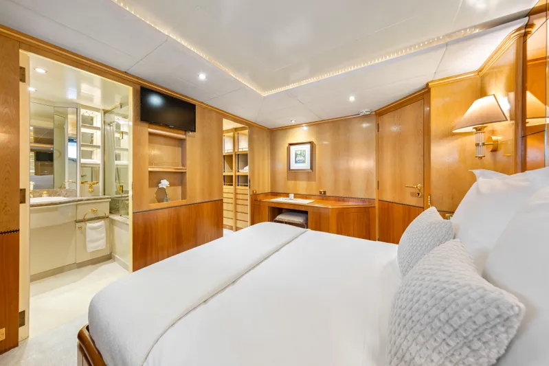 Mistress Yacht Photos Pics Luxurious bedroom interior on 1991 Benetti 46m yacht, featuring elegant wood finishes and modern amenities.