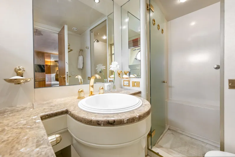 Mistress Yacht Photos Pics Luxurious bathroom on 1991 Benetti 46m yacht with marble countertop and gold fixtures.