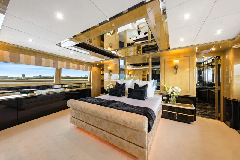 Mistress Yacht Photos Pics Luxurious bedroom interior on a 1991 Benetti 46m yacht, featuring elegant decor and large windows.