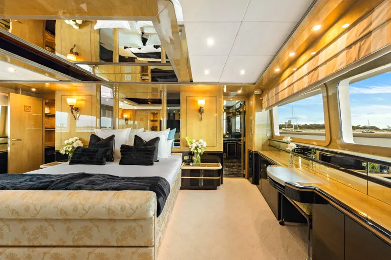 Mistress Yacht Photos Pics Luxurious bedroom interior on a 1991 Benetti 46m yacht, featuring elegant decor and large windows.