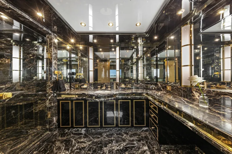 Mistress Yacht Photos Pics Luxurious black marble bathroom on a 1991 Benetti 46m yacht, featuring elegant gold accents.