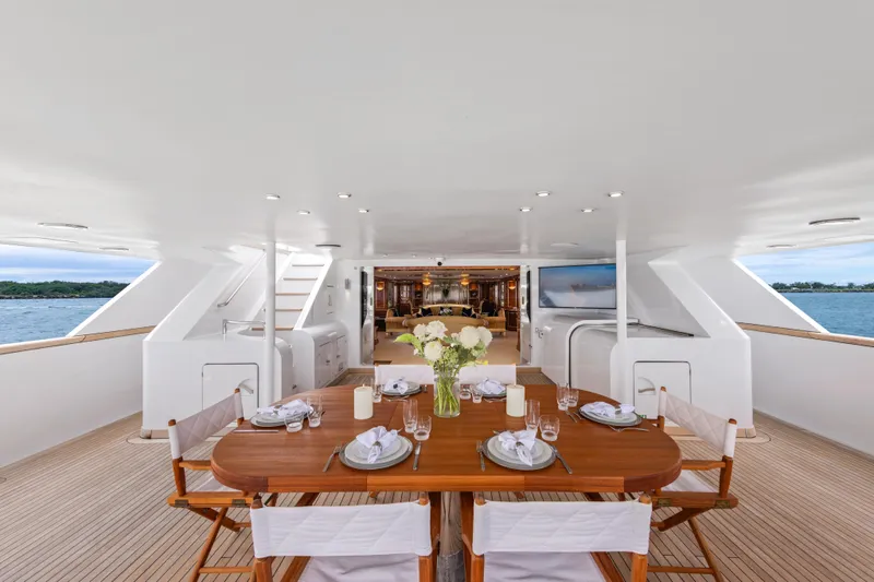 Mistress Yacht Photos Pics Luxurious Benetti 46m yacht deck with elegant dining setup, ocean view, built in 1991.