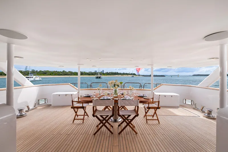 Mistress Yacht Photos Pics Luxurious Benetti 46m yacht deck with dining setup, ocean view, built in 1991.