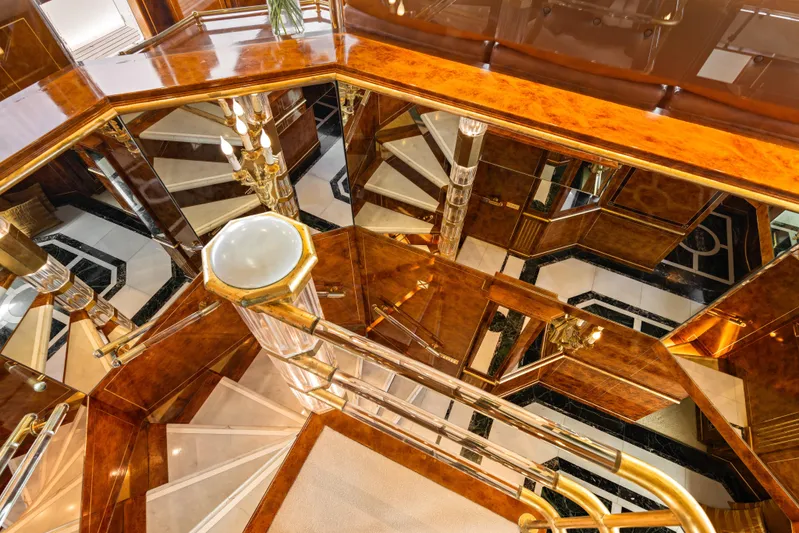 Mistress Yacht Photos Pics Luxurious interior staircase of a 1991 Benetti 46m yacht, featuring elegant wood and mirrored accents.