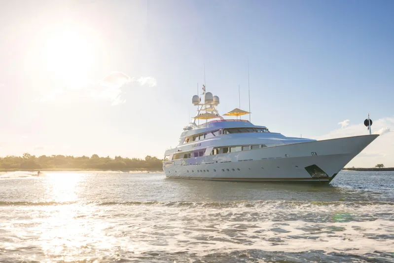 Mistress Yacht Photos Pics Luxurious 1991 Benetti 46m yacht cruising on serene waters at sunset.
