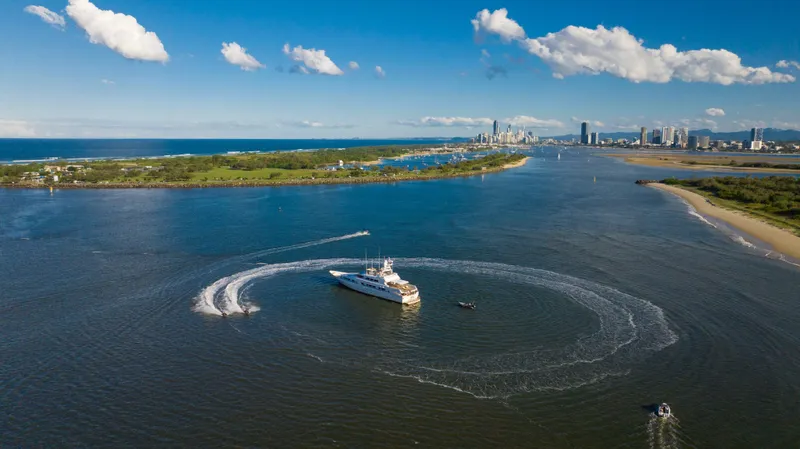Mistress Yacht Photos Pics Aerial view of 1991 Benetti 46m yacht cruising in a scenic coastal waterway.