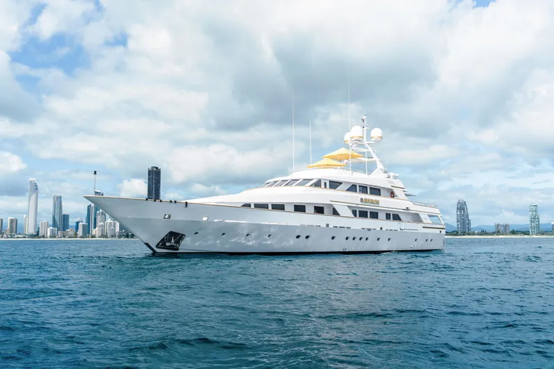 Mistress Yacht Photos Pics Luxurious 1991 Benetti 46m yacht cruising near a modern city skyline.