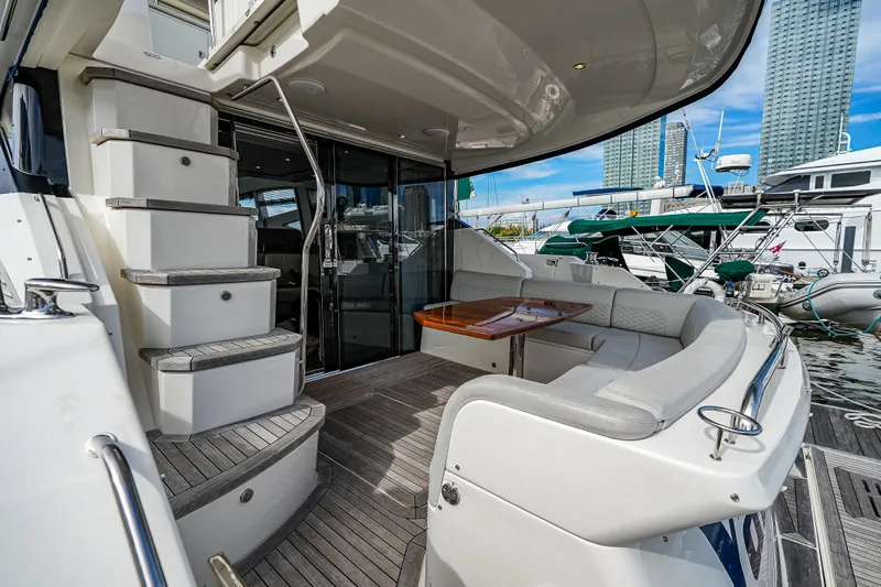 Yan Ge Yacht Photos Pics 2018 Sea Ray L590 Fly yacht with elegant seating and staircase, docked at a marina.