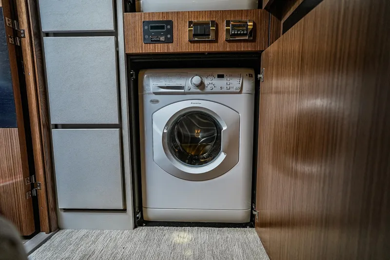 Yan Ge Yacht Photos Pics Washing machine in 2018 Sea Ray L590 Fly yacht interior, surrounded by wood paneling.