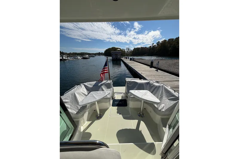 Luna Yacht Photos Pics 2020 Back Cove 37 boat docked, featuring covered seating and American flag.