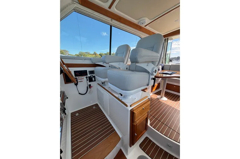 Luna Yacht Photos Pics 2020 Back Cove 37 interior with helm seats and wooden flooring.