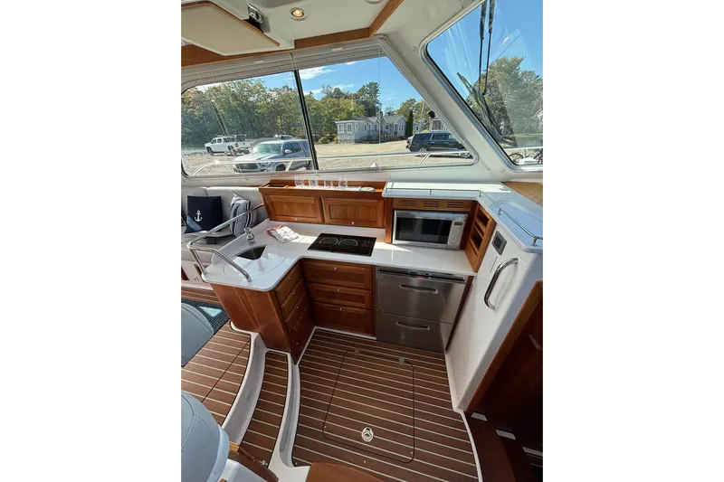 Luna Yacht Photos Pics 2020 Back Cove 37 yacht interior with modern kitchen, wood flooring, and large windows.