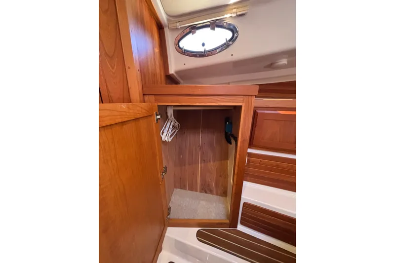 Luna Yacht Photos Pics 2020 Back Cove 37 interior wooden closet with hangers and porthole.