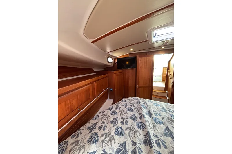 Luna Yacht Photos Pics 2020 Back Cove 37 yacht interior with wood paneling and floral bedding.