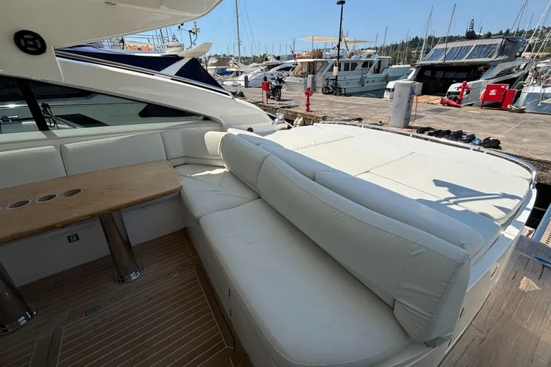  Yacht Photos Pics Luxurious 2006 Princess V53 yacht with elegant white seating and wooden table at marina.