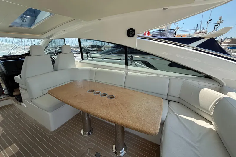  Yacht Photos Pics Luxurious interior of 2006 Princess V53 yacht with white seating and wooden table.