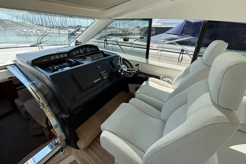  Yacht Photos Pics Interior view of 2006 Princess V53 yacht helm with plush seating and control panel.