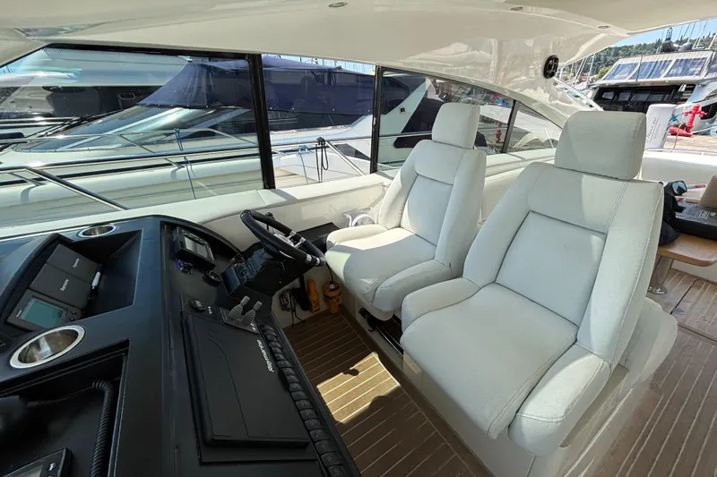  Yacht Photos Pics Interior of 2006 Princess V53 yacht with helm and white seating.