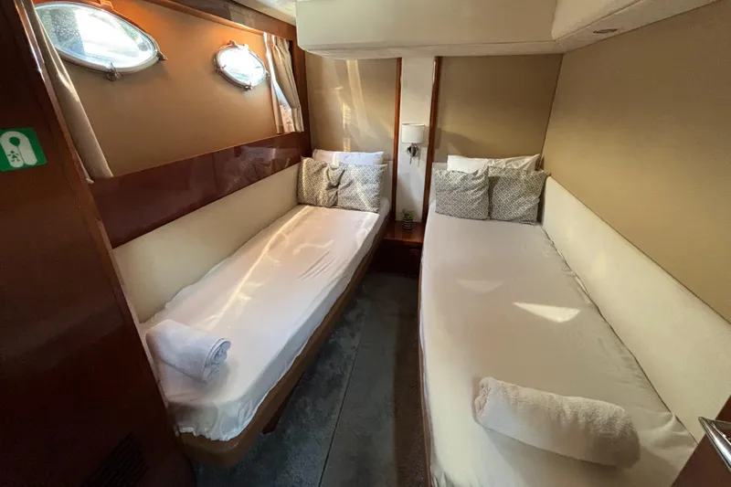  Yacht Photos Pics Twin cabin interior of 2006 Princess V53 yacht with cozy beds and porthole windows.