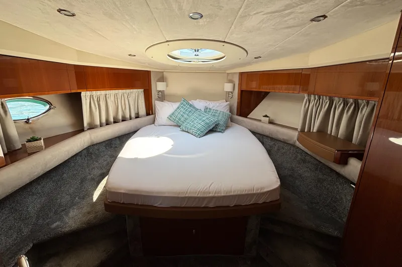  Yacht Photos Pics Luxurious 2006 Princess V53 yacht cabin with elegant wood finishes and cozy bedding.