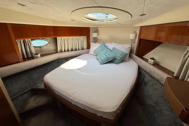  Yacht Photos Pics Luxurious cabin interior of 2006 Princess V53 yacht with cozy bed and elegant decor.