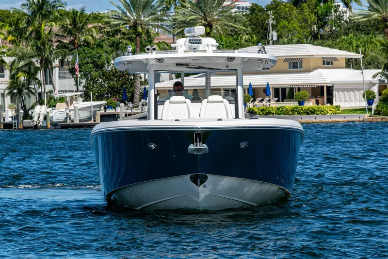  Yacht Photos Pics 2020 Everglades 395 Center Console boat cruising on a sunny waterfront.